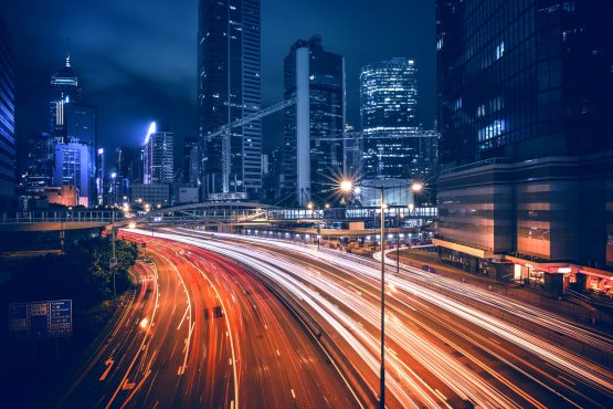 imagem de uma grande avenida de uma megalópole à noite repleta de rastros de luzes feitos por carros, ilustrando artigo sobre as profissões do futuro