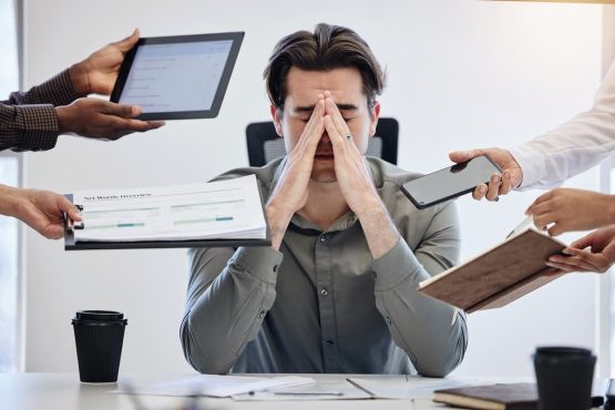 Homem parecendo cansado em seu ambiente de trabalho e