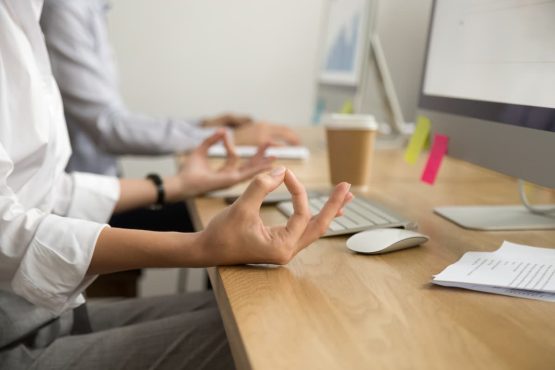 Imagem de um homem fazendo yoga no ambiente de trabalho